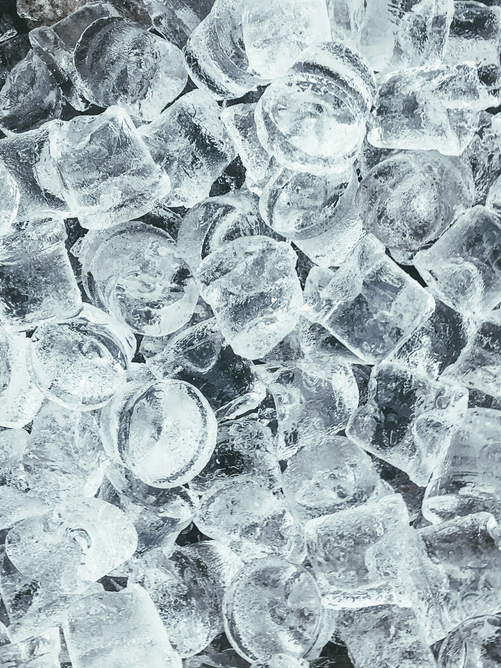 Close-up of clear ice cubes stacked together with light reflecting off their surfaces